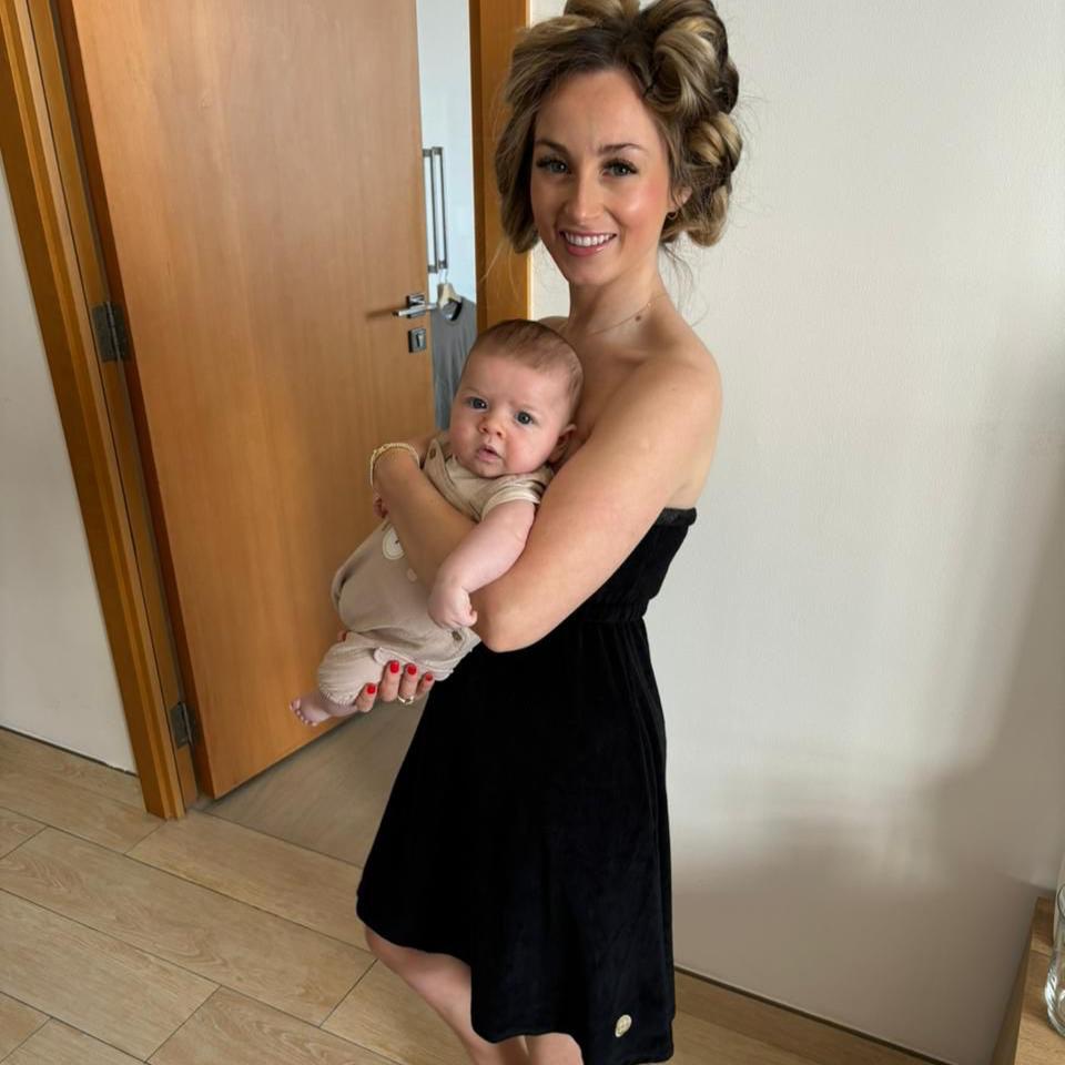Mother wearing the Black Classic Dry Dolly towel dress, holding a baby with rollers in her hair — showing ease, comfort, and practicality for busy mums