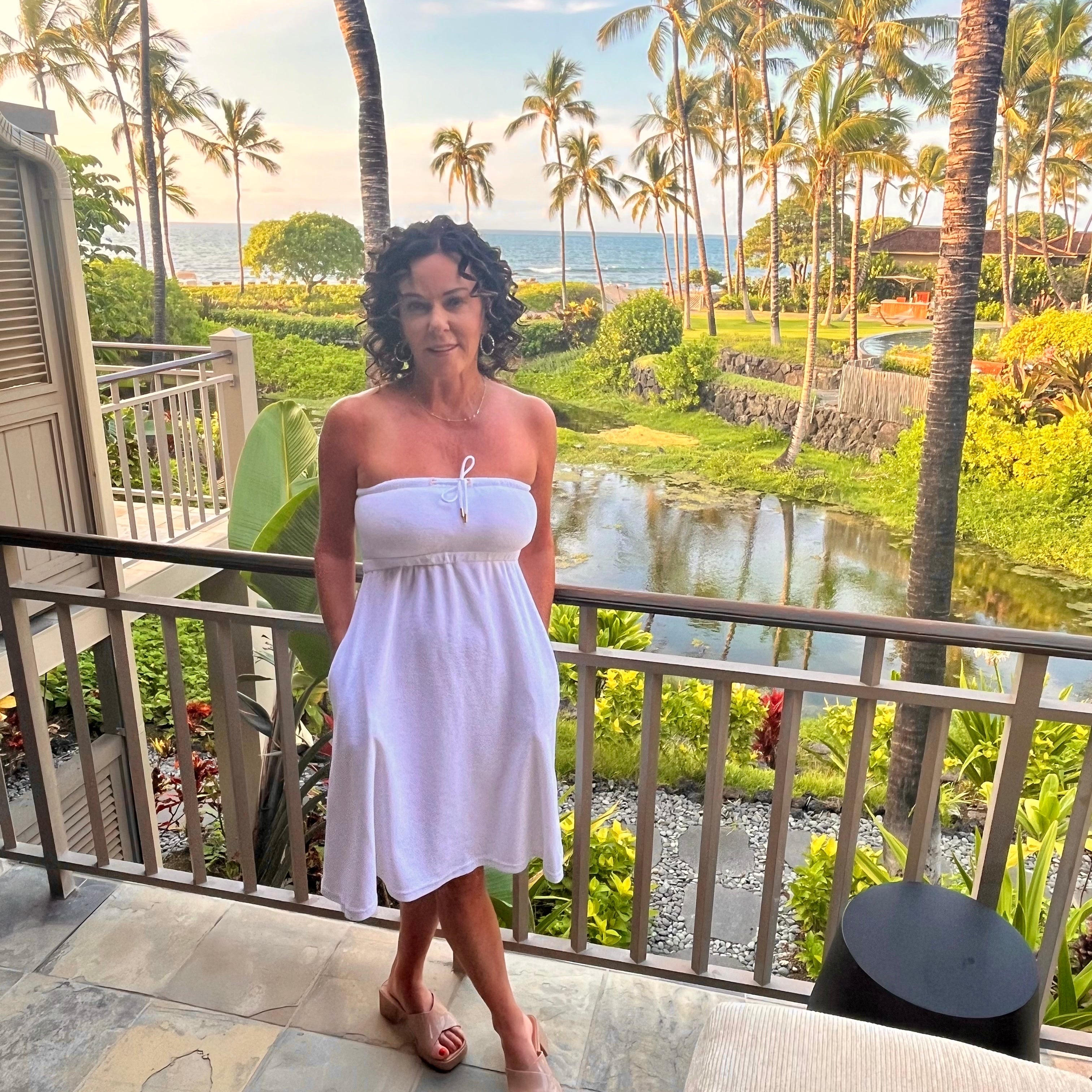 Woman wearing the White Classic Dry Dolly towel dress at a luxury hotel in Hawaii, capturing effortless post-swim elegance and resort comfort